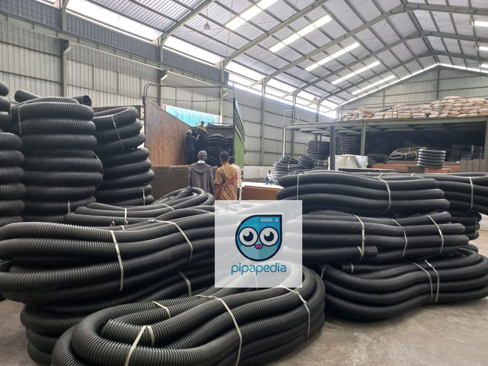 Satu per satu pipa HDPE dimasukkan ke dalam truk fuso untuk dikirim ke padang