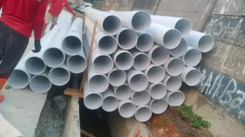 Tumpukan pipa PVC Gavin yang diturunkan di lokasi proyek drainase trotoar Meruya, Jakarta Barat